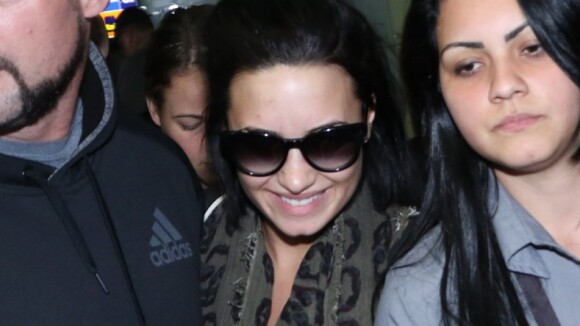 Demi Lovato desembarca no Brasil para show privado e tem bolsa puxada por fã