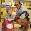 Felipe Simas posou orgulhoso ao lado do filho, Joaquim, sentado em um carrinho em uma loja de brinquedos