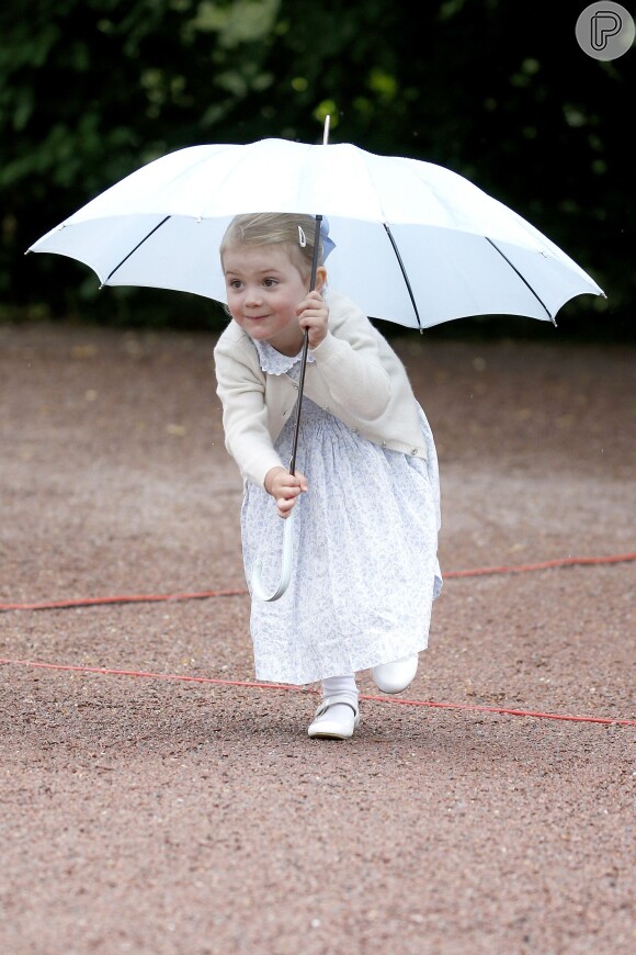 A princesa Estelle, da Suécia, faz graça com uma sombrinha enquanto se protege do sol no aniversário da mãe, a princesa Victória, em julho de 2015