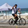 Em passeio de bicicleta na orla da praia, o ator cumprimenta o paparazzi com simpatia