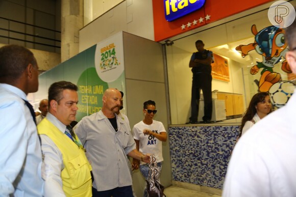 Alicia Keys é acompanhada por seguranças antes de embarcar para São Paulo