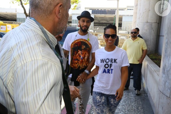 De mãos dadas com o marido, Alicia Keys sorri para fotógrafos que a aguardavam na entrada do aeroporto, no Rio