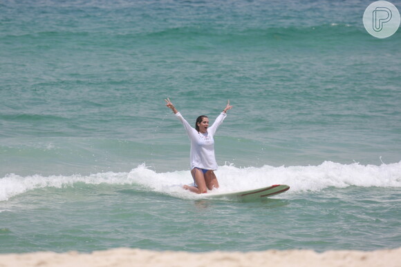 Deborah Secco comemora ao ficar de joelhos sobre a prancha de surf