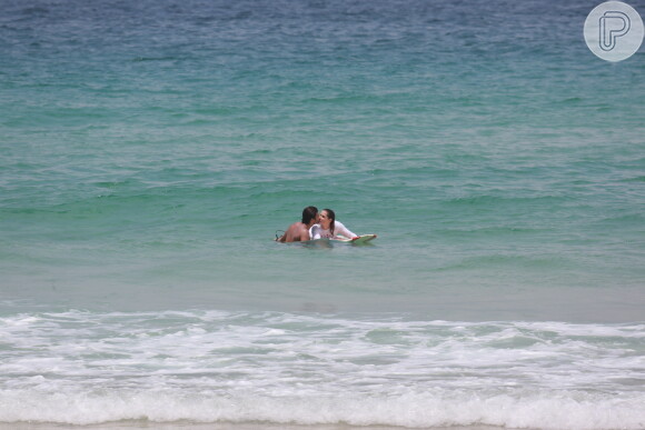 Deborah Secco e o marido, Hugo Moura, trocam beijos na praia