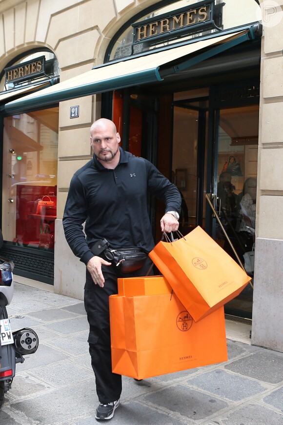 Kim Kardashian precisa da ajuda de seu segurança, que carrega as sacolas da grife Hermès
