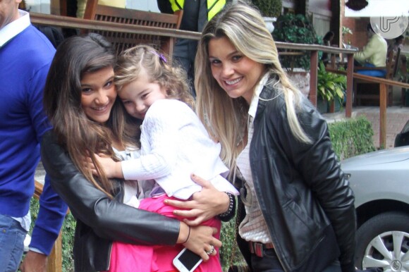 Flávia Alessandra sorri com Giulia e Olivia para os fotógrafos de plantão