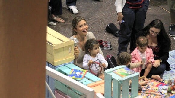 Grazi Massafera senta no chão e brinca com a filha, Sofia, em shopping do Rio