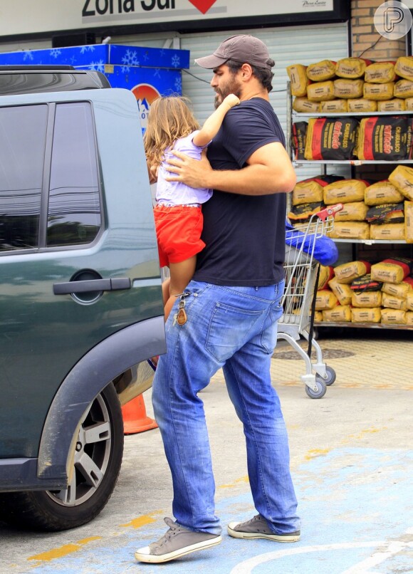 Thiago Lacerda coloca a filha Cora, de 3 anos, no carro após ir ao supermercado