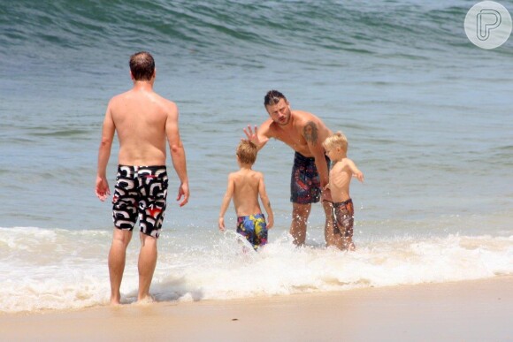 Rodrigo Hilbert entra na água com os filhos João e Francisco