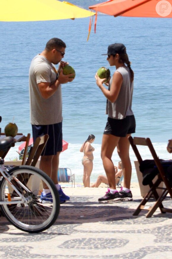 O casal pedalou na orla da praia do Leblon e tomou água de coco em um quiosque para repor as energias, em 19 de novembro de 2013
