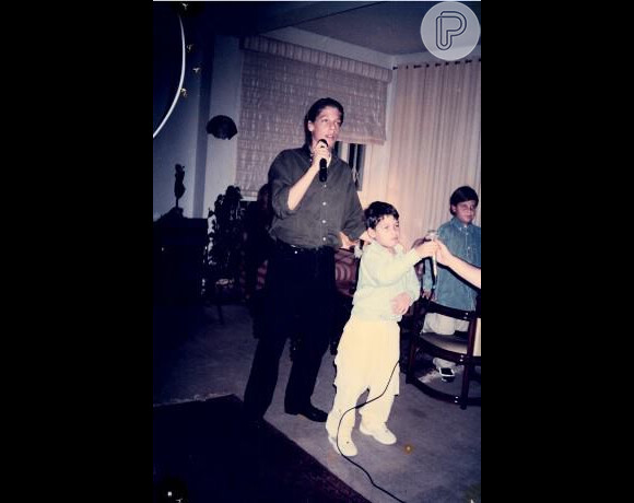 Quando era adolescente, Fábio Porchat era alto e magro. Na foto, ele de roupa social cantando no karaokê com o primo durante um aniversário da mãe