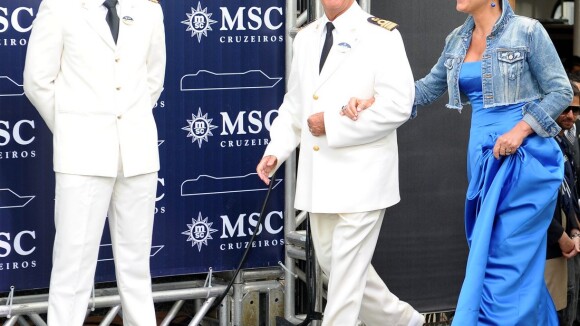 Xuxa participa de lançamento de navio com vestido longo azul e bota ortopédica