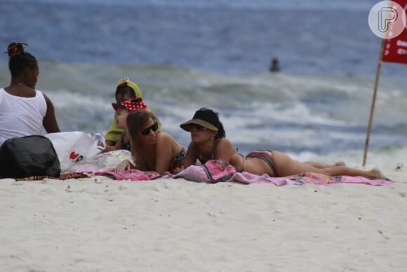 Juliana Knust exibiu a boa forma em um biquíni listrado neste sábado, 14 de dezembro de 2013, ao lado de uma amiga, na praia da Barra da Tijuca, Zona Oeste do Rio de Janeiro
