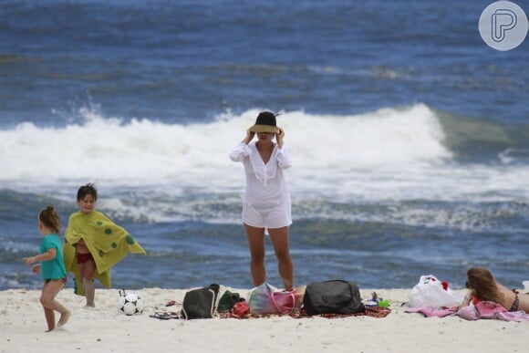 A atriz Juliana Knust se arruma para deixar a praia da Barra da Tijuca, Zona Oeste do Rio de Janeiro, neste sábado, 14 de dezembro de 2013