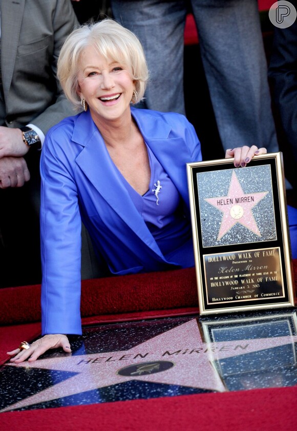 Helen Mirren sorri exibindo a placa de homenagem com a sua estrela da Calçada da Fama de Hollywood, em Los Angeles, Estados Unidos, em 3 de janeiro de 2013