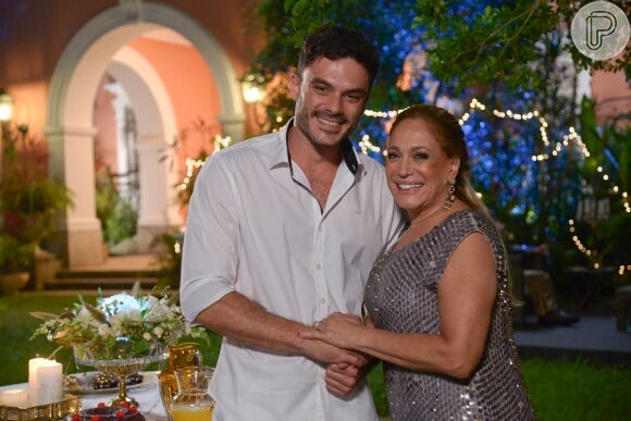 Pilar (Susana Vieira) assume seu relacionamento com Maciel (Kiko Pissolato) na frente de seus convidados, na festa de Réveillon em 'Amor à Vida'
