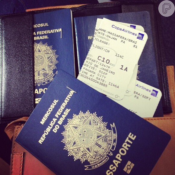 Grazi mostra os passaportes pouco antes de embarcar no Rio, na sexta-feira, 4 de janeiro de 2013