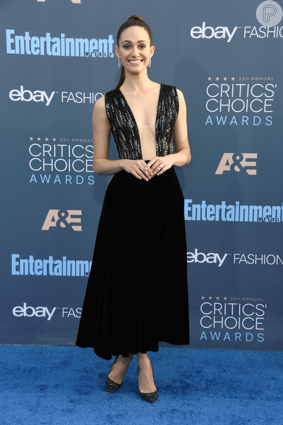 A atriz Emmy Rossum usou um vestido superdecotado da grife Giorgio Armani, coleção inverno 2016, para ir ao Critics Choice Awards, em Los Angeles, Estados Unidos, realizado neste domingo, 11 de dezembro de 2016