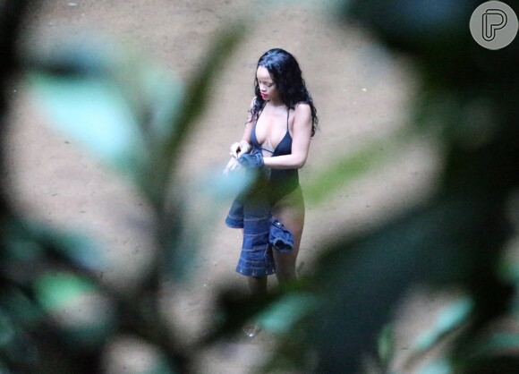 Rihanna termina de tirar blusa para entrar na cachoeira