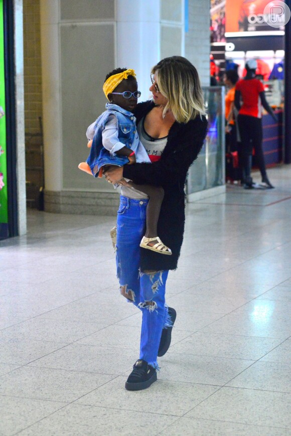 Giovanna Ewbank, a caminho do baile de Carnaval organizado pela revista Vogue, levou a filha no colo antes do embarque