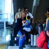Giovanna Ewbank pega a filha, Títi, no colo ao sair da escada rolante