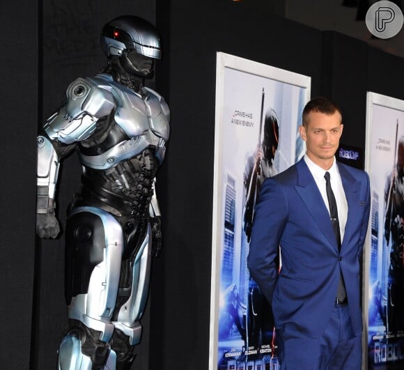 Joel Kinnaman, protagonista de 'RoboCop', posa ao lado de estátua do robô
