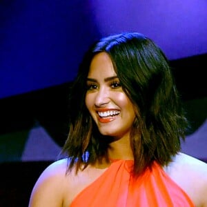 Demi Lovato escolheu um look laranja com recortes laterais para a premiação