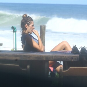 Mariana Goldfarb observa o namorado, Cauã Reymond, surfando na Prainha 