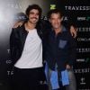 Caio Castro posa sorridente ao lado do ator Chico Buaz no lançamento do filme 'Travessia'