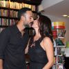 Carolina Ferraz beija Marcelo Marins na frente dos fotógrafos na noite de autógrafos do seu livro de culinária