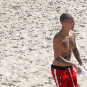 Sem camisa, Justin Bieber exibiu a barriga tanquinho na praia de Ipanema, Zona Sul do Rio