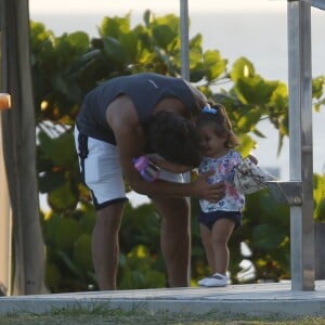 Hugo Moura faz carinho na filha, Maria Flor, em dia de praia