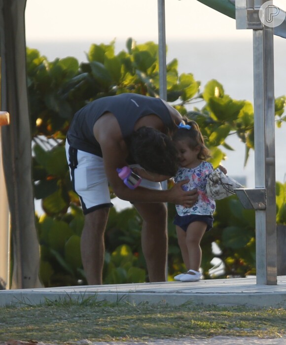 Hugo Moura faz carinho na filha, Maria Flor, em dia de praia