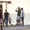 Hugo Moura conversa com amigos durante tarde na praia com a filha, Maria Flor