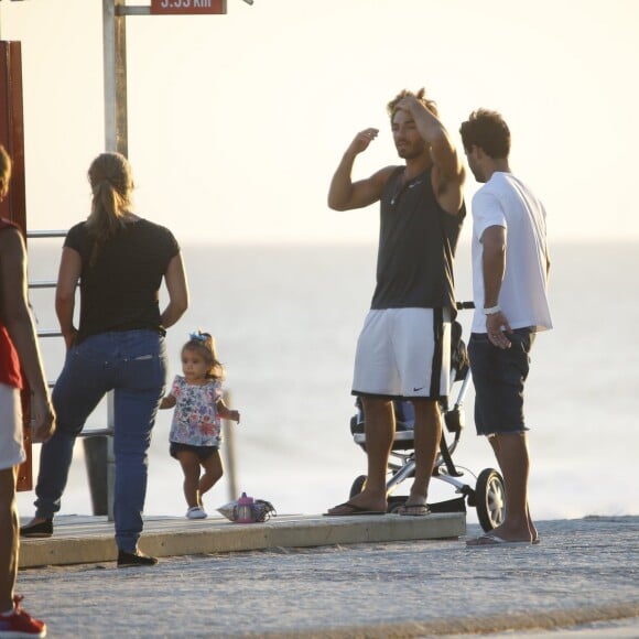 Hugo Moura conversa com amigos durante tarde na praia com a filha, Maria Flor