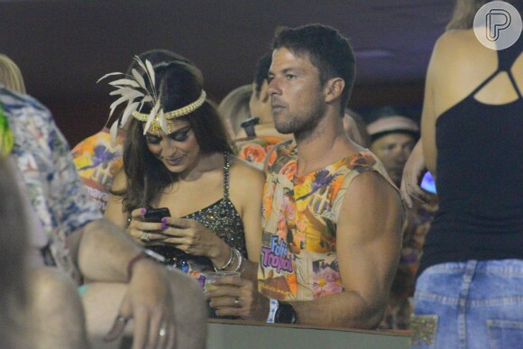 Juliana Paes não conseguiu desgrudar do celular enquanto dividia as atenções entre os desfiles das escolas de samba e o maridão