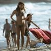 Alice (Sophie Charlotte) vai à praia com a família e é fotografada ao fazer topless em protesto, na supersérie 'Os Dias Eram Assim'