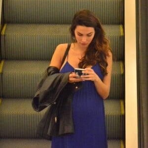 Mel Fronckowiak, grávida de Rodrigo Santoro, mexe no celular durante passeio em shopping da Gávea