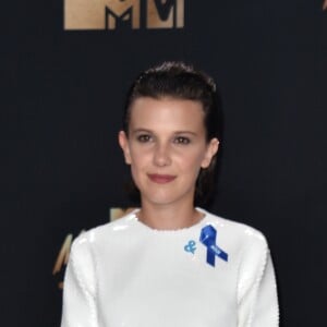 Premiada por sua atuação em 'Stranger Things', Millie Bobby Brown usou botas brancas com o vestido Calvin Klein no MTV Movie and TV Awards, que aconteceu em Los Angeles, Estados Unidos, na noite deste domingo, 7 de maio de 2017