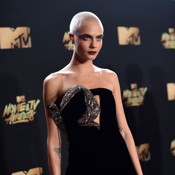 Cara Delevingne usou botas com o vestido Saint Laurent no MTV Movie and TV Awards, que aconteceu em Los Angeles, Estados Unidos, na noite deste domingo, 7 de maio de 2017