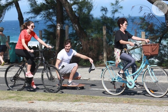Camila Queiroz se diverte ao pedalar em passeio com a mãe e o namorado, Klebber Toledo