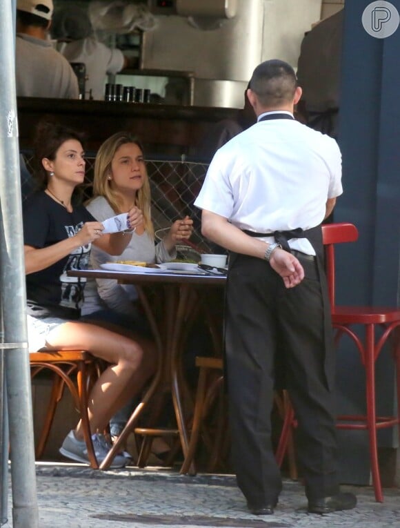 Fernanda Gentil e a namorada, Priscila Montandon, conversam com garçom em restaurante no Rio de Janeiro