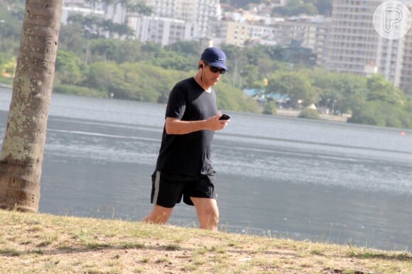 William Bonner checa o celular durante caminhada na Lagoa Rodrigo de Freitas, no Rio de Janeiro, em 16 de maio de 2017