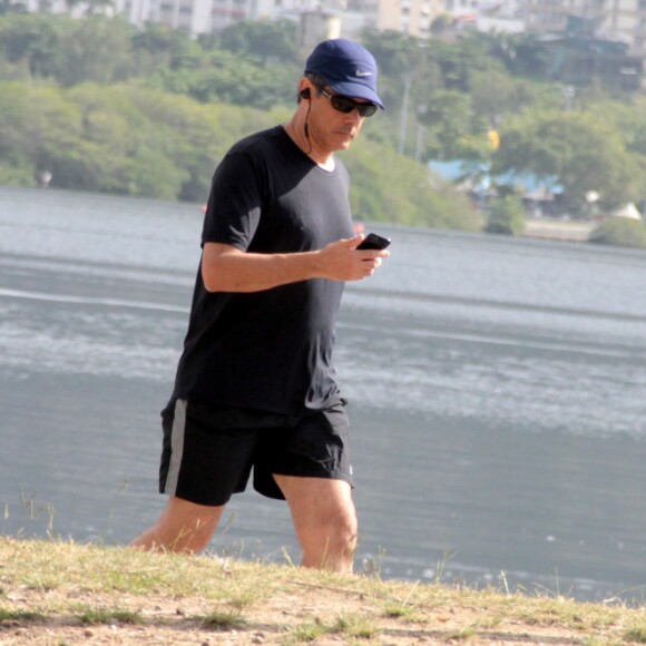 William Bonner checa o celular durante caminhada na Lagoa Rodrigo de Freitas, no Rio de Janeiro, em 16 de maio de 2017