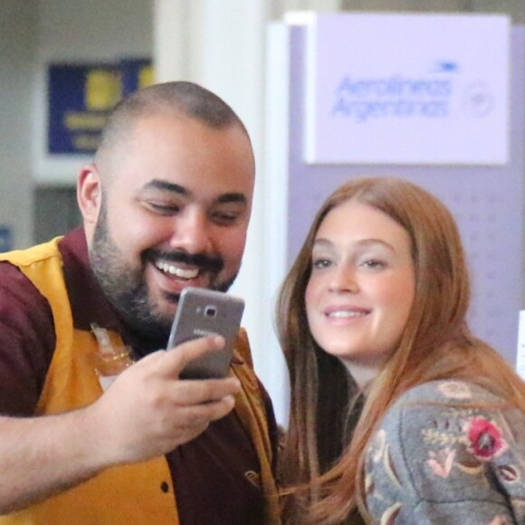 Marina Ruy Barbosa posa com funcionário do aeroporto na fila de embarque