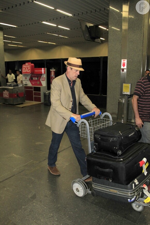 Hugh Laurie chegou elegante usando calça jeans, blazer bege e chapéu Panamá 