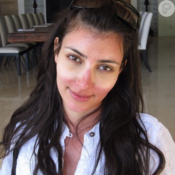 Kim Kardashian dorme no sol com óculos escuros e fica marcada