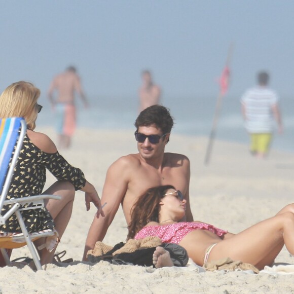 Isis Valverde deita no colo do namorado em dia de praia no Rio