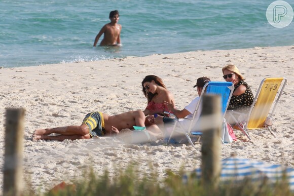 Isis Valverde curte praia com o namorado, André Resende, e mostra boa forma