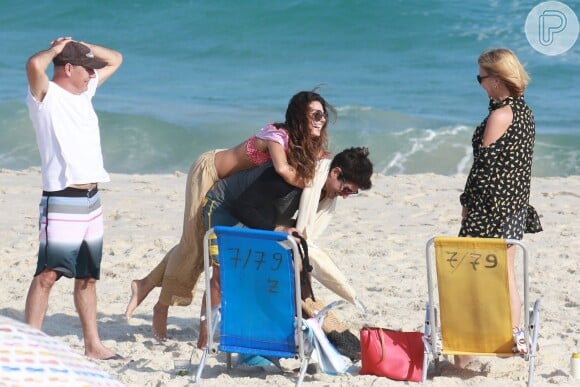 Isis Valverde se diverte ao pular no namorado, o modelo André Resende, em dia de praia